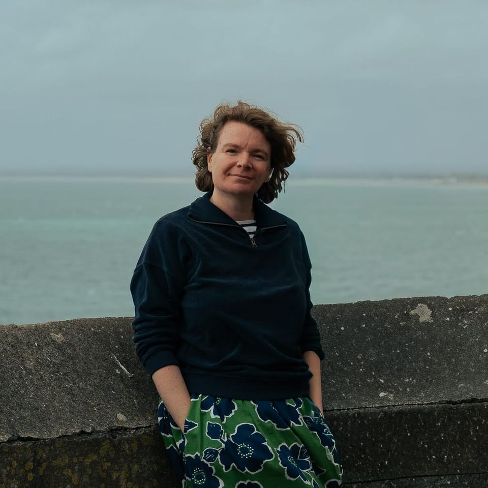 Cécile sur la plage de Granville à marée basse, la vieille ville en arrière-plan